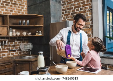 Happy Father Making Cereal Breakfast For Daughter While They Preparing For Work And School