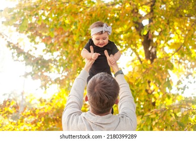 Happy Father Play With The Baby. The Man Holding The Toddler In The Hands And Have Fun Laughing, Throwing The Child Up As If The Kid Flying