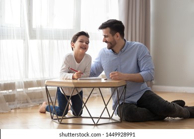 Happy Father Playing With Adorable Little Son, Drawing Colored Pencils, Sitting On Warm Floor, Excited Dad And Preschool Child Boy Having Fun At Home, Laughing Together, Underfloor Heating Concept