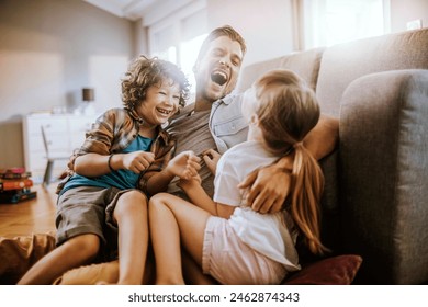 Happy father playing with son and daughter at home - Powered by Shutterstock