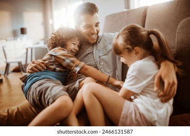 Happy father playing with son and daughter at home - Powered by Shutterstock