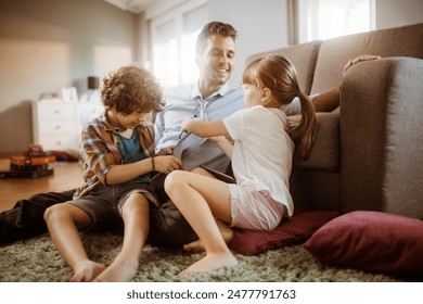 Happy father playing with son and daughter at home - Powered by Shutterstock