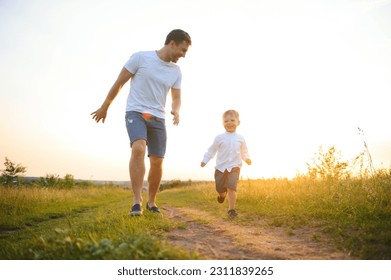 Happy father playing with son on sunset background .The concept of father's day.