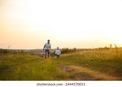 Happy father playing with son on sunset background .The concept of father's day. - Powered by Shutterstock