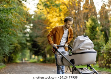 happy father pushing infant baby stroller and walking in the park. Spending time with newborn and breathing fresh air. - Powered by Shutterstock