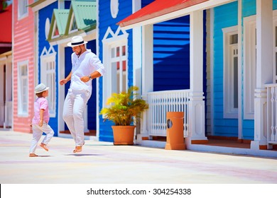 happy father and son enjoy life, dancing on caribbean village street