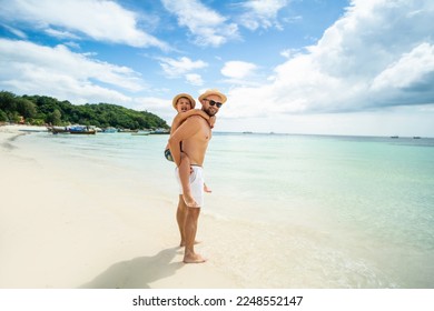 Happy father and son enjoying time at sandy tropical beach during family vacation. Boys having fun together. Real people lifestyle. Tourism. Traveler.
 - Powered by Shutterstock