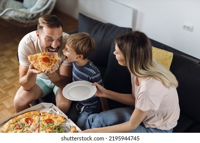 Happy father and son enjoying while eating pizza  at home - Powered by Shutterstock