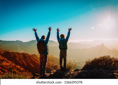 Happy father and son hiking at sunset mountains - Shutterstock ID 1366295378