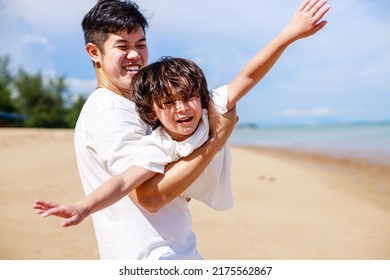Happy Father and son playing together on the tropical beach. Happy vacation and travel on beach