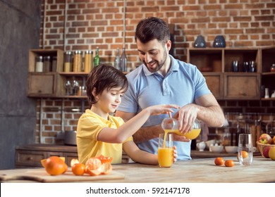 Happy father and son pouring fresh juice in glass - Powered by Shutterstock