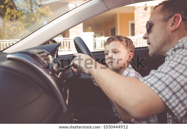 Happy\
father and son sitting in the car at the day time. People getting\
ready for road trip. Concept of happy\
family.