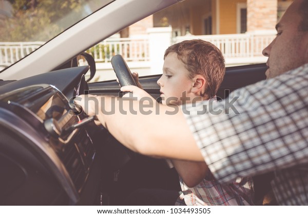 Happy\
father and son sitting in the car at the day time. People getting\
ready for road trip. Concept of happy\
family.