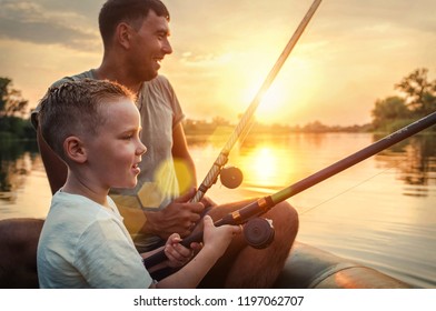 Fröhlicher Vater und Sohn zusammen angeln von einem Boot bei Sonnenuntergang im Sommer unter schönem Himmel auf dem See.