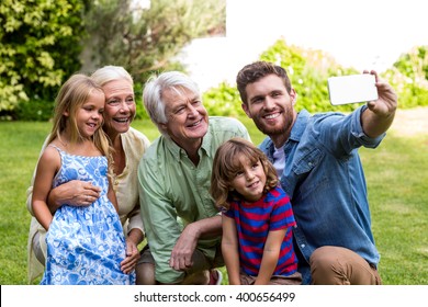 Happy father taking selfie with family while sitting in yard - Powered by Shutterstock