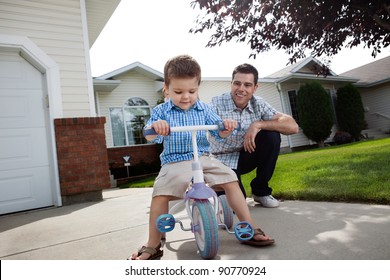 Happy father teaching his adorable son to ride a tricycle - Powered by Shutterstock