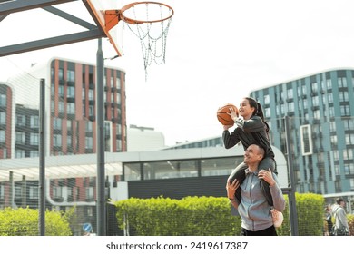 Happy father and teen daughter outside at basketball court. - Powered by Shutterstock