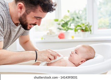 Happy Father Washes His Baby Caring With The Washcloth