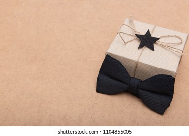 Happy Father's Day Background. Beautiful retro style gift box and black bow tie on brown background. Fathers day still life. - Powered by Shutterstock