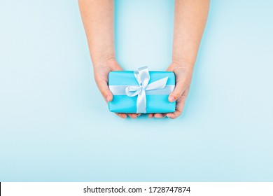 Happy Fathers Day Background. Kid Holding Hands Blue Gift Box On Table. Flat Lay Style, Top View, Overhead, Mockup