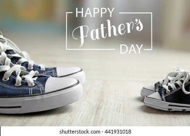 Happy Father's Day Concept. Big And Small Shoes On Wooden Floor