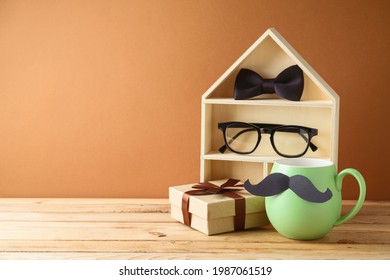 Happy Fathers day concept with green coffee cup, toy house and gift box on wooden table - Powered by Shutterstock