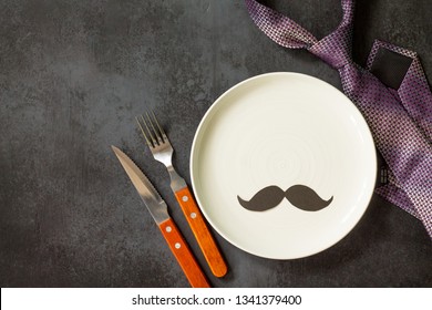 Happy Fathers Day Concept. Table Setting - Plate, Tie, Cutlery And Napkin On Grey Stone Table. Top View Flat Lay Background With Copy Space.