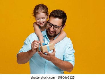 happy father's day! cute dad and daughter hugging on colored yellow background
 - Powered by Shutterstock