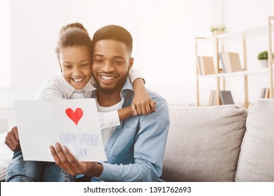 Happy father's day. Daughter congratulating dad and giving him postcard, free space