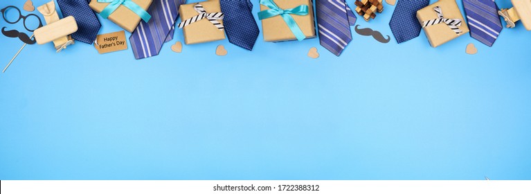 Happy Fathers Day gift tag with long border of ties, gifts and games on a blue banner background. Above view with copy space.