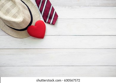 Happy Father's Day inscription with colorful tie,red heart and hat on wooden background floor backround.