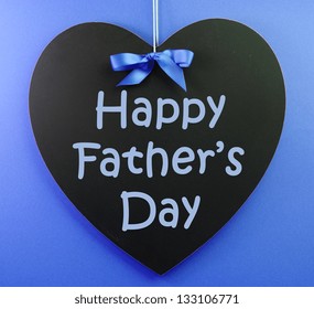 Happy Fathers Day Message Written On A Black Blackboard With Blue Ribbon Against A Blue Background.