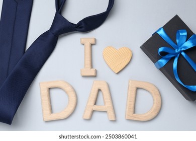 Happy Father's Day. Phrase I love Dad made with wooden letters, gift and tie on light background, flat lay - Powered by Shutterstock