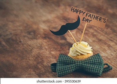 Happy fathers day special cupcake and bow tie on wooden table - Shutterstock ID 395530639