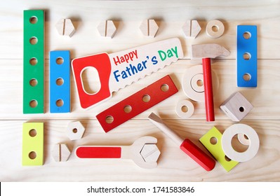 Happy Father's day tools. Wooden toys, including a hammer, a saw, a wrench and a screwdriver. - Powered by Shutterstock