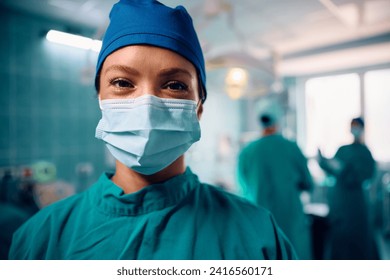 Happy female anesthesiologist during the surgery in operating room looking at camera.  - Powered by Shutterstock