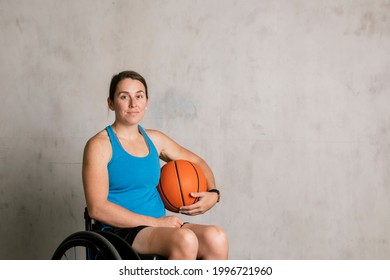 Happy Female Athlete In A Wheelchair With A Basketball