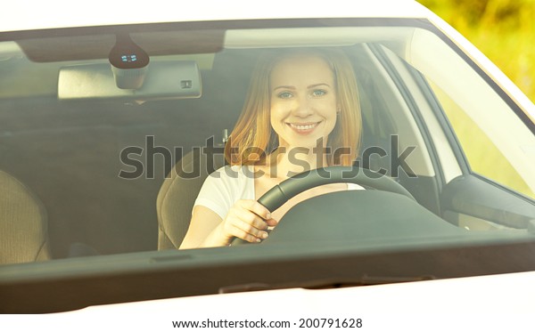 happy female driver driving a\
car