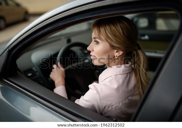 Happy\
female driver driving a new car.New driver in\
town