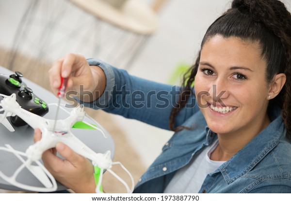 happy female drone\
pilot dismantling drone