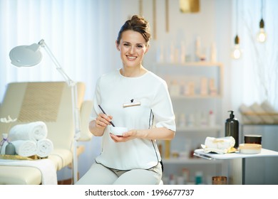 happy female employee in modern beauty salon working.