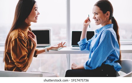 Happy female employees having fun together discussing successful project in office, cheerful Caucasian colleagues communicating and sharing creative strategies near table with laptop computers - Shutterstock ID 1917475736