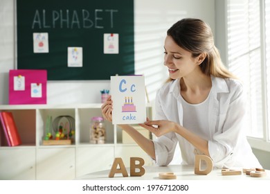 Happy Female English Teacher Giving Lesson In Elementary School