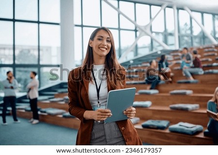 Happy female entrepreneur attending a business seminar in conference hall and looking at camera.