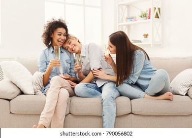 Happy female friends chatting and drinking wine at home. Three young women having friendly talk, gossiping and celebrating new life, slumber party, copy space