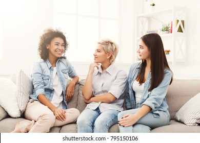 Happy female friends chatting at home. Three young women having friendly talk, gossiping and smiling, slumber party, copy space - Powered by Shutterstock