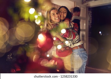 Happy Female Friends Hugging And Celebrating Christmas
