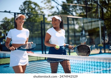 Happy female friends leaving the court after playing paddle tennis - Powered by Shutterstock