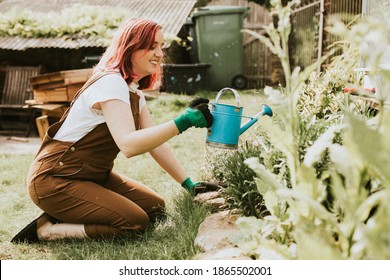 Happy Female Gardener Watering Plants