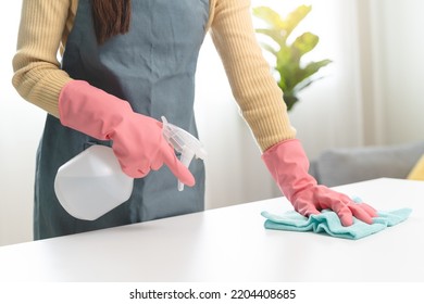 happy Female housekeeper service worker wiping table surface by cleaner product to clean dust. - Shutterstock ID 2204408685